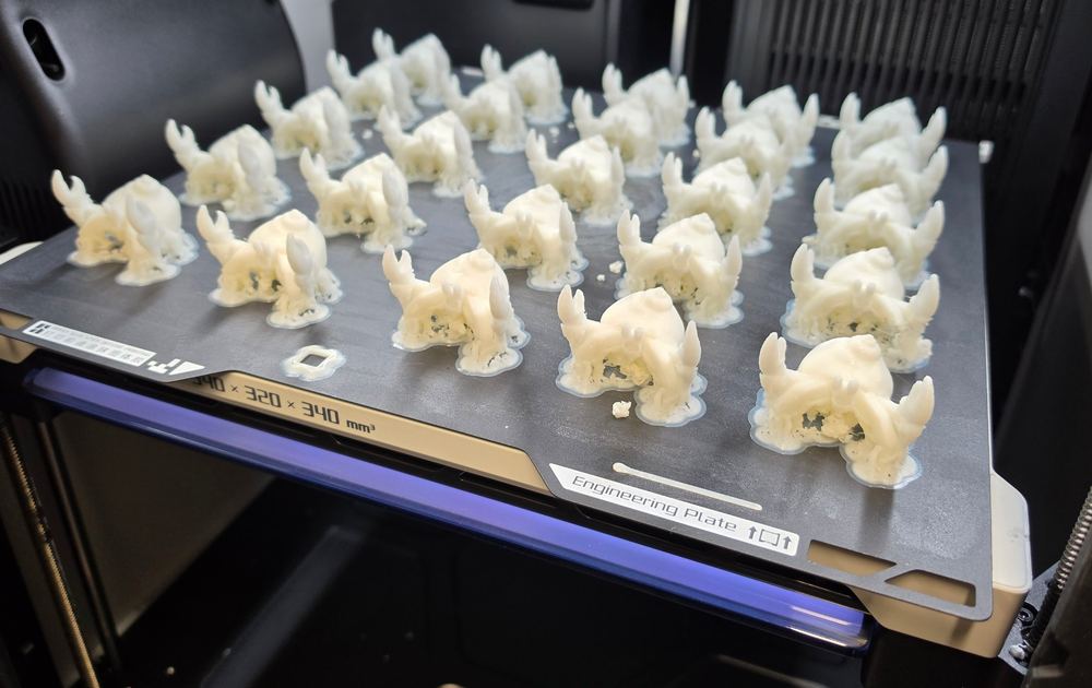 3Dプリンタの造形台の上に、できたばかりの白いやどかりがずらりと並んでいる
